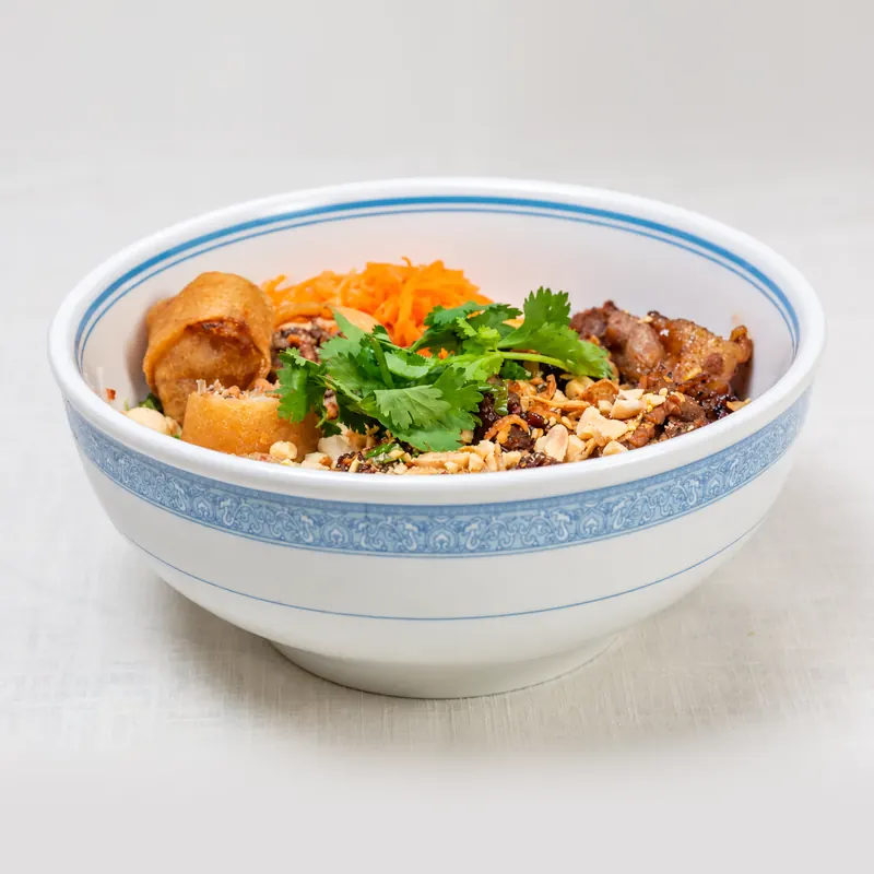 Grilled pork and egg roll vermicelli bowl with pickled carrot, crushed peanuts and cilantro