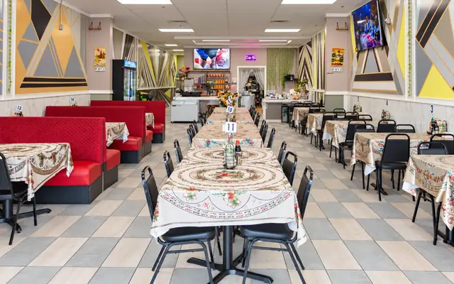 Red booths and long family tables in the Elisa Pho dining room