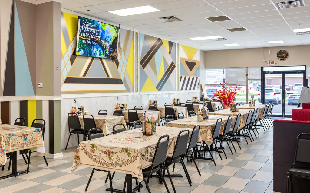Rows of tables in the Elisa Pho dining room under bright murals